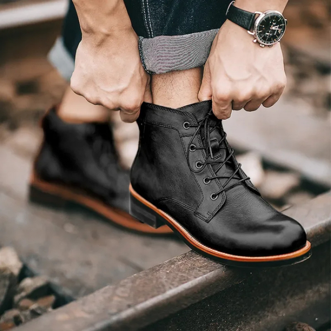 Man tying black lace-up ankle boots