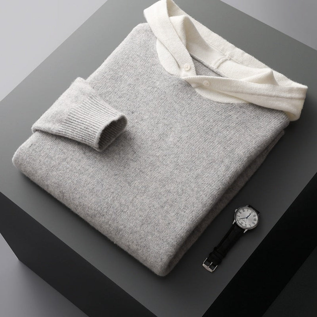 Grey knit hoodie folded with a watch