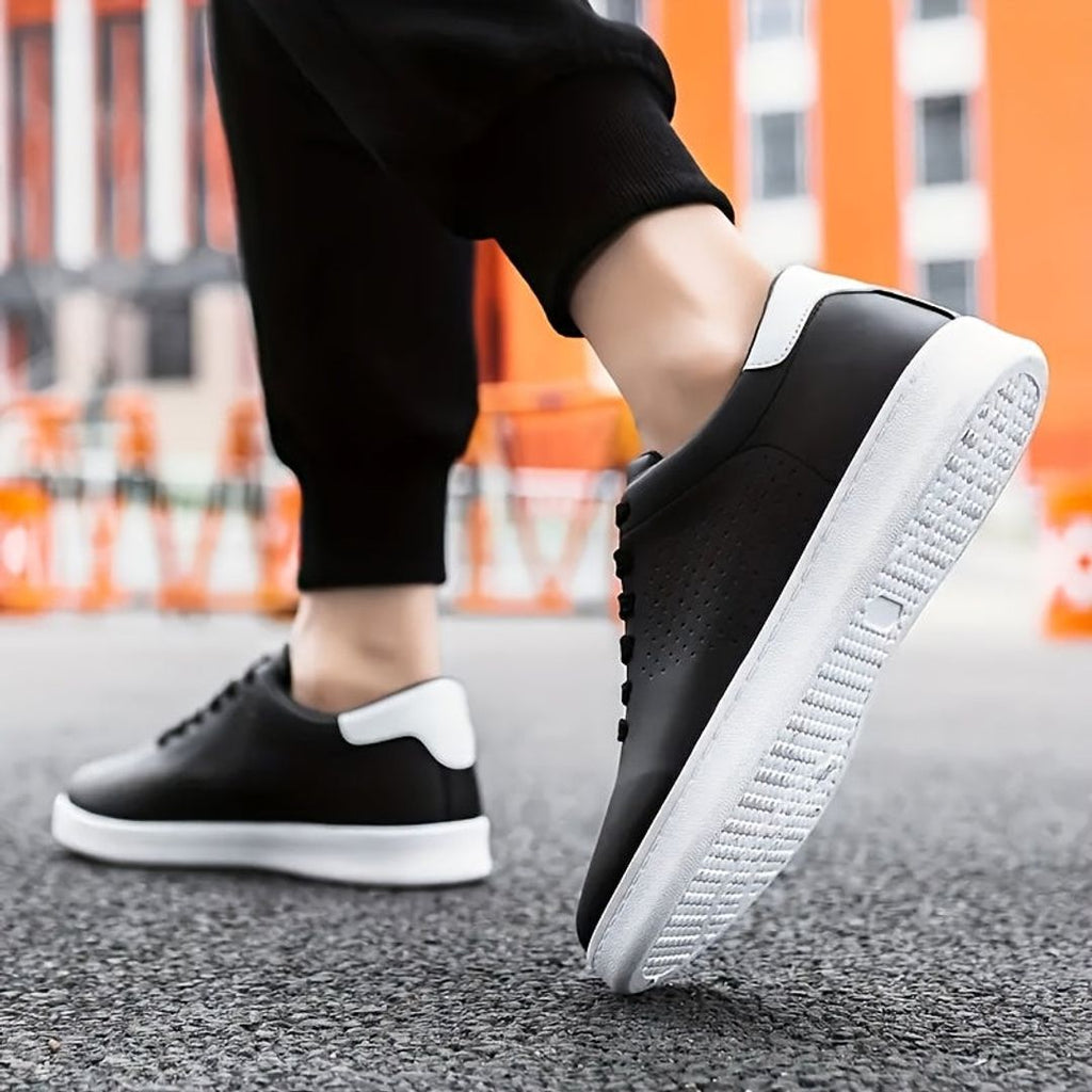 Men's perforated low top sneakers in black, worn
