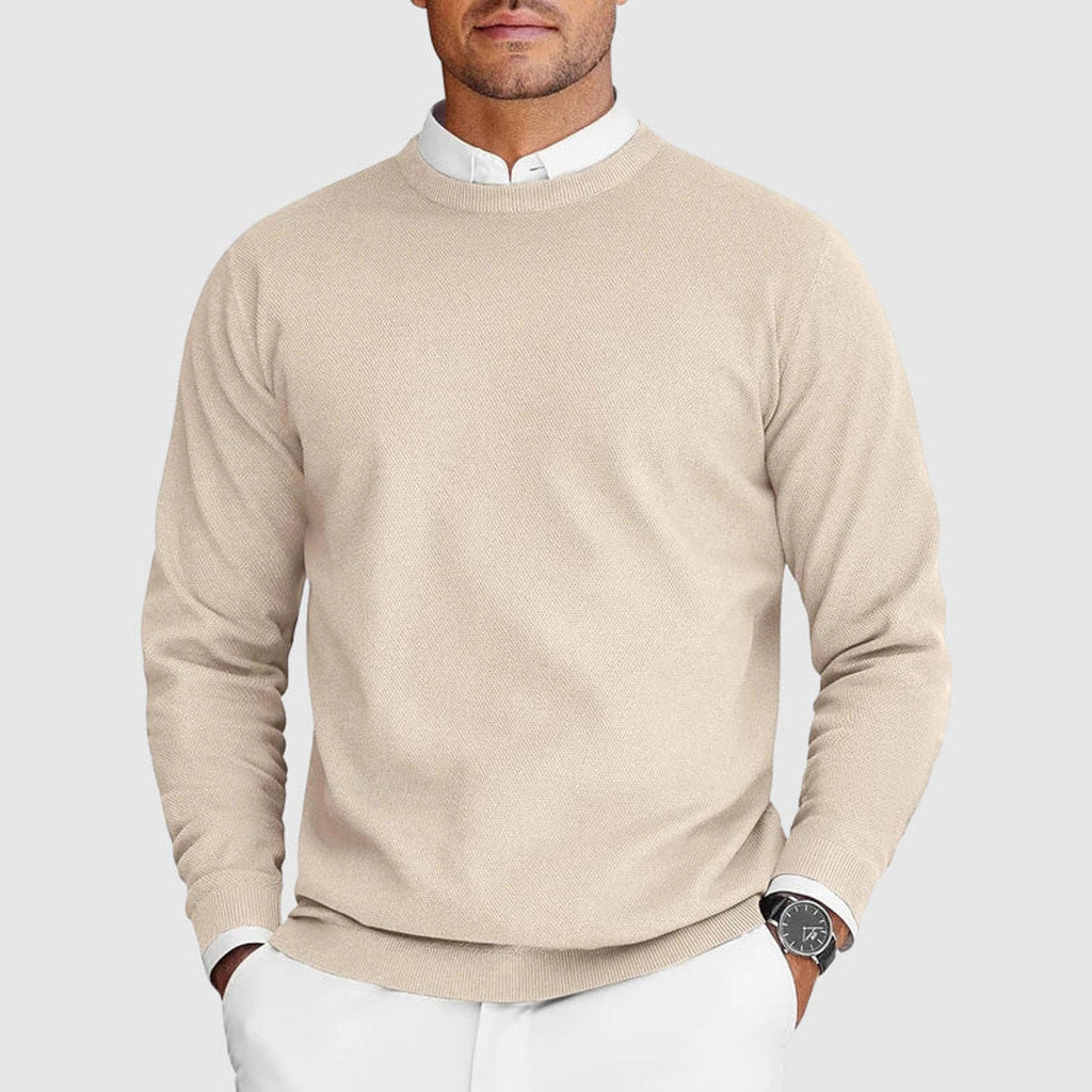 Man wearing a beige crew neck sweater over a shirt