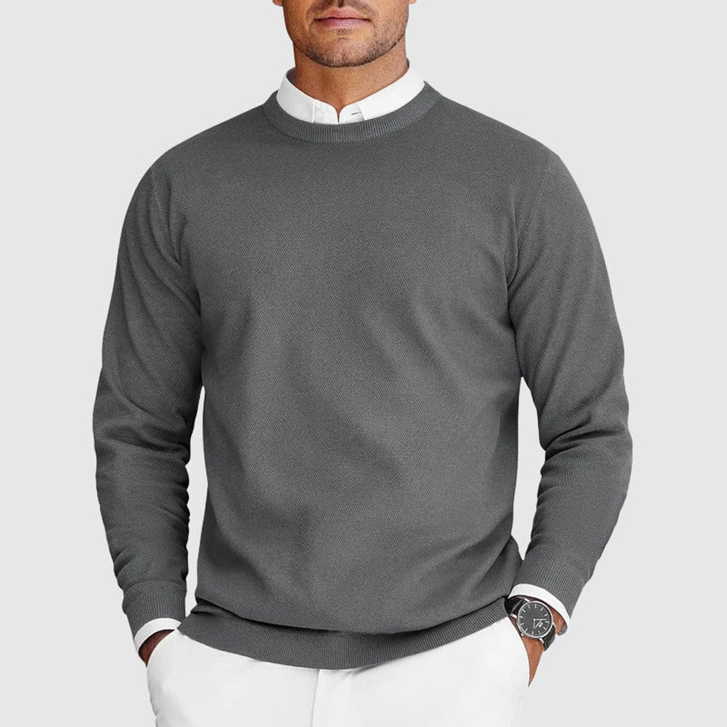 Man wearing a grey crew neck knit sweater