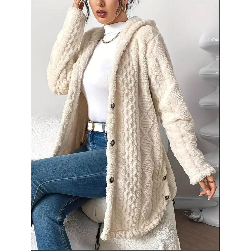 Woman sitting in a beige cable knit cardigan