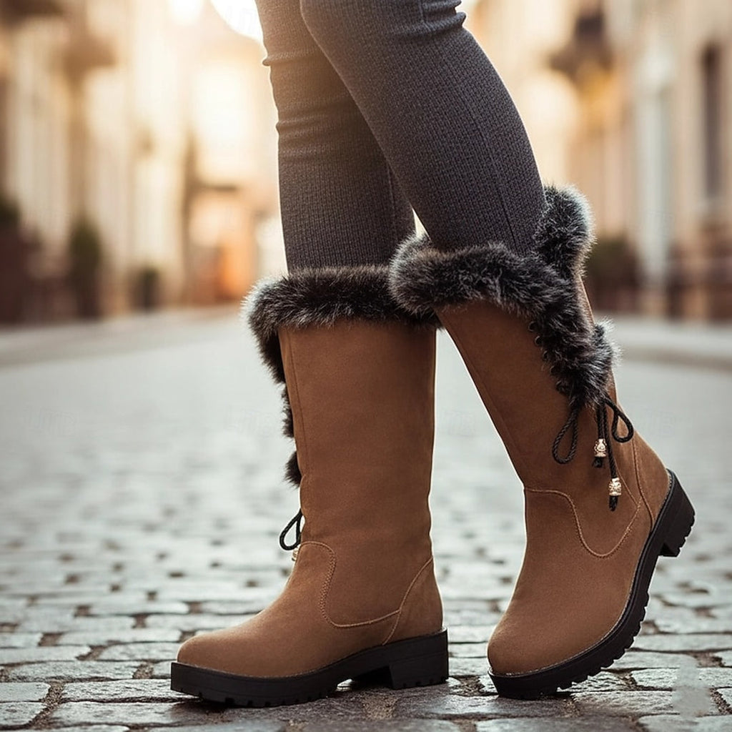 Women's camel lace-up winter boots with fluffy cuff on a cobbled street