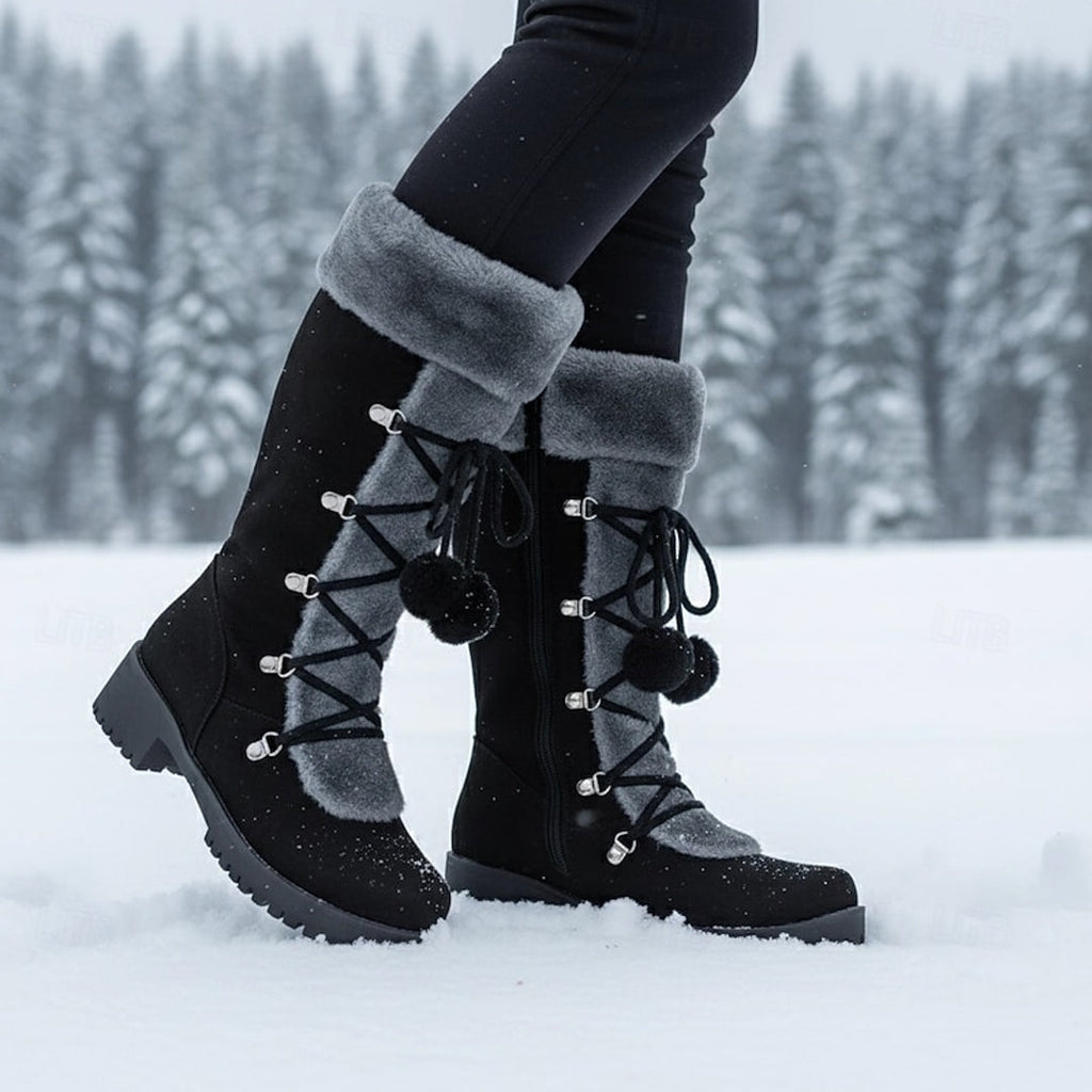 Women's black lace-up winter boots with fluffy cuff in the snow
