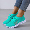 Woman wearing turquoise knit lace-up sneakers