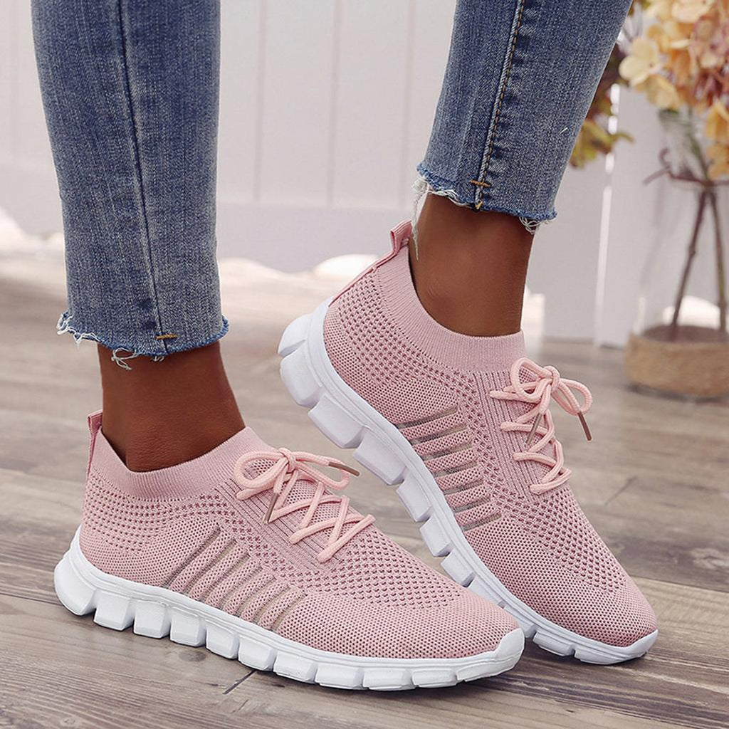 Woman wearing pink knit sneakers with jeans