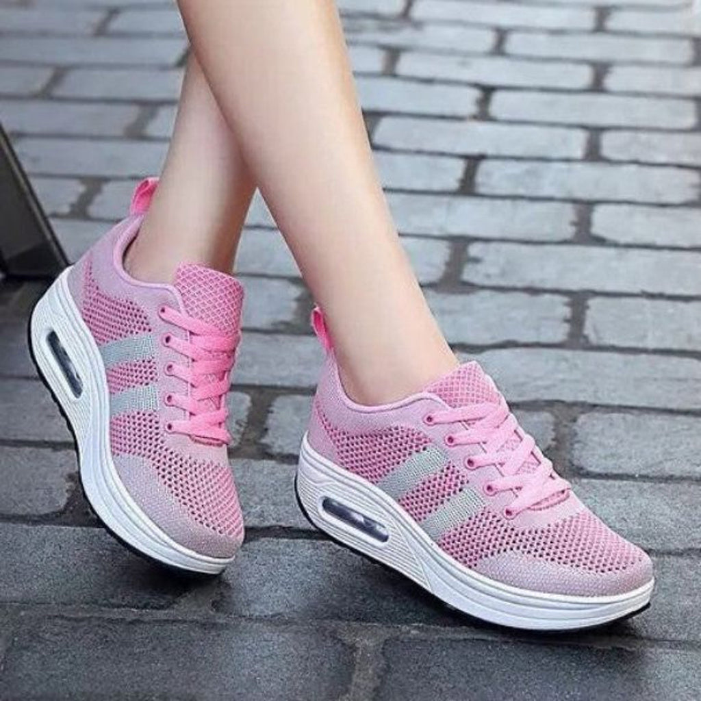 Woman wearing pink mesh sneakers with grey stripes