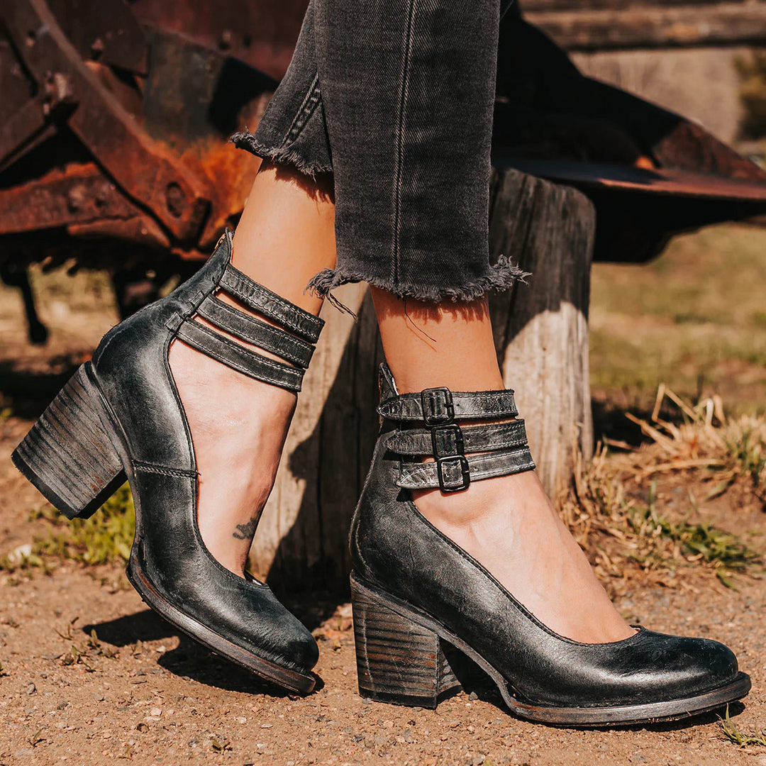 Woman wearing black multi-strap block heel ankle boots