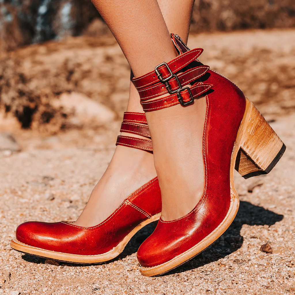 Woman wearing red ankle boots with buckle straps