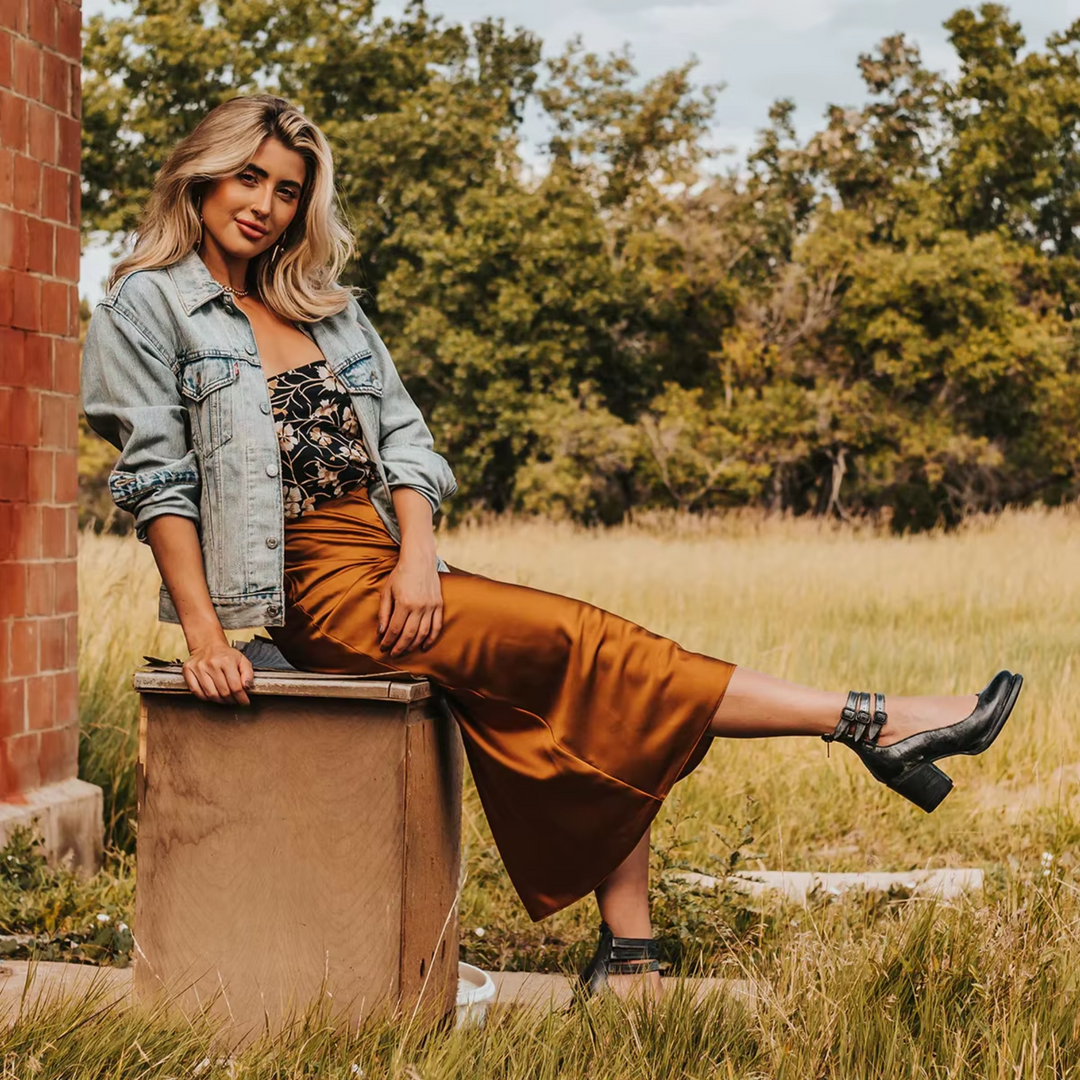 Woman sitting outdoors in multi-strap ankle boots