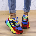 Woman wearing blue rainbow chunky sneakers with cuffed jeans