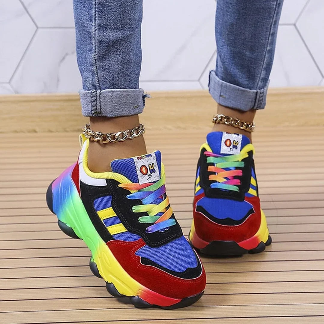 Woman wearing blue rainbow chunky sneakers with cuffed jeans