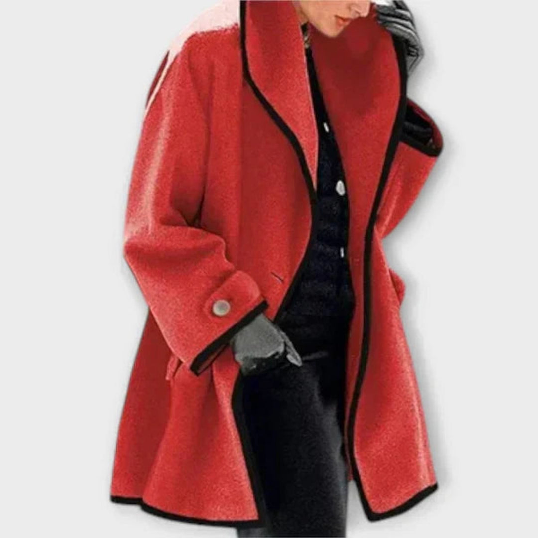 Woman wearing a red A-line coat with black trim