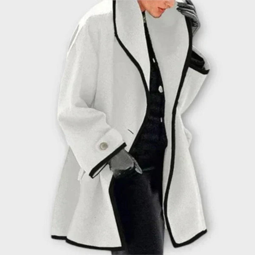 Woman wearing a white coat with dark contrast trim