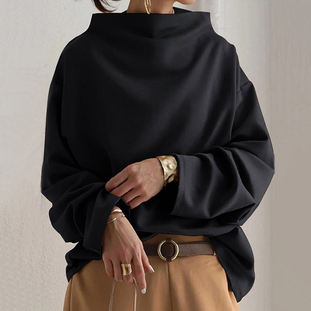 Woman wearing a black batwing sweater with brown trousers
