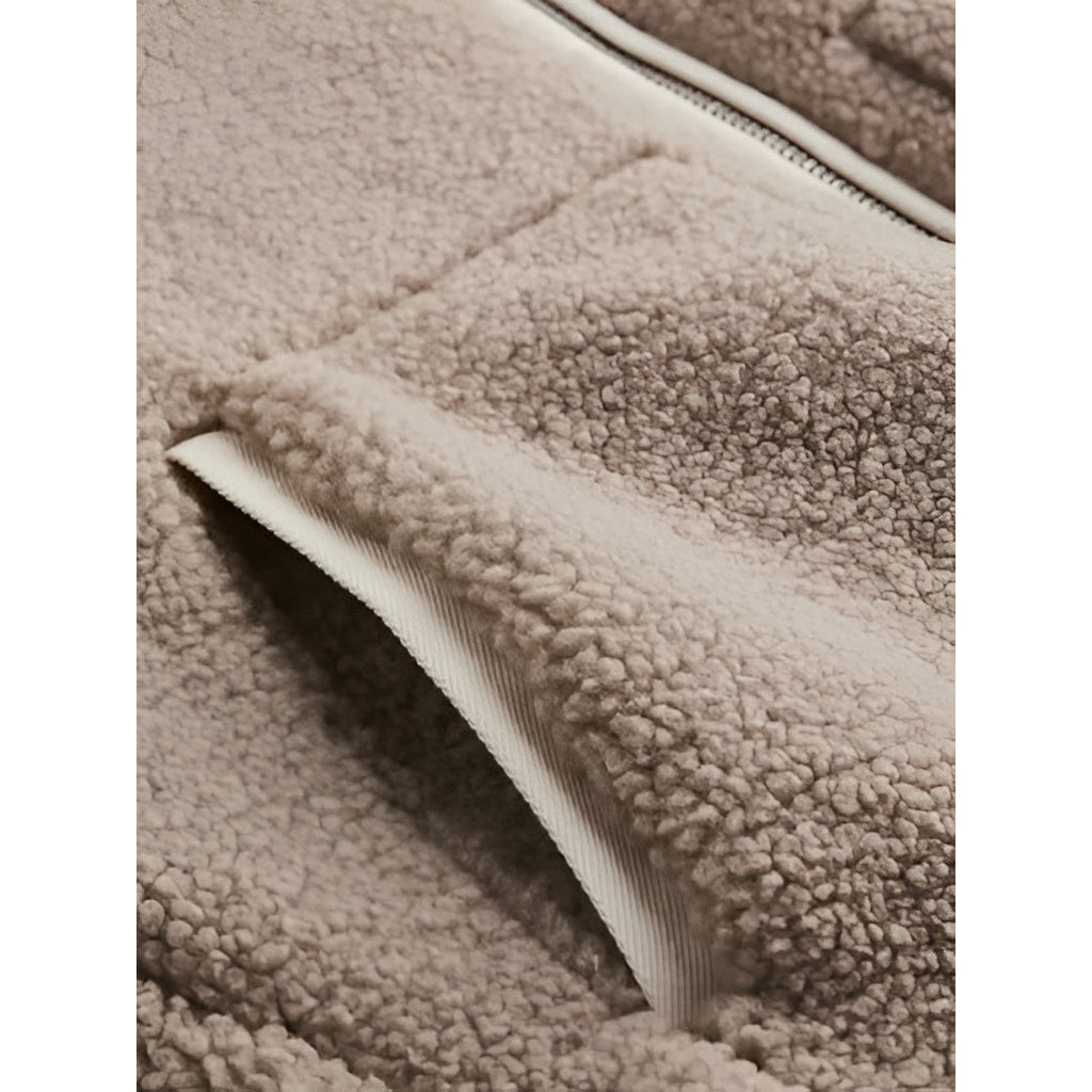 Close-up of the teddy texture and pocket on the taupe jacket