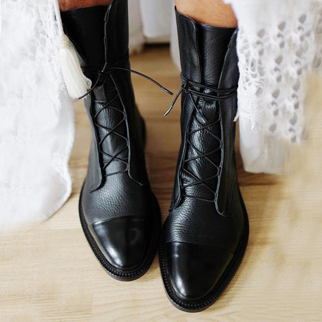 Woman wearing black polished lace-up ankle boots
