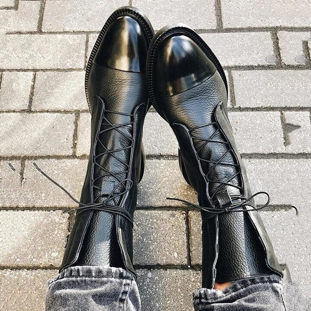 Black lace-up ankle boots on a tiled floor