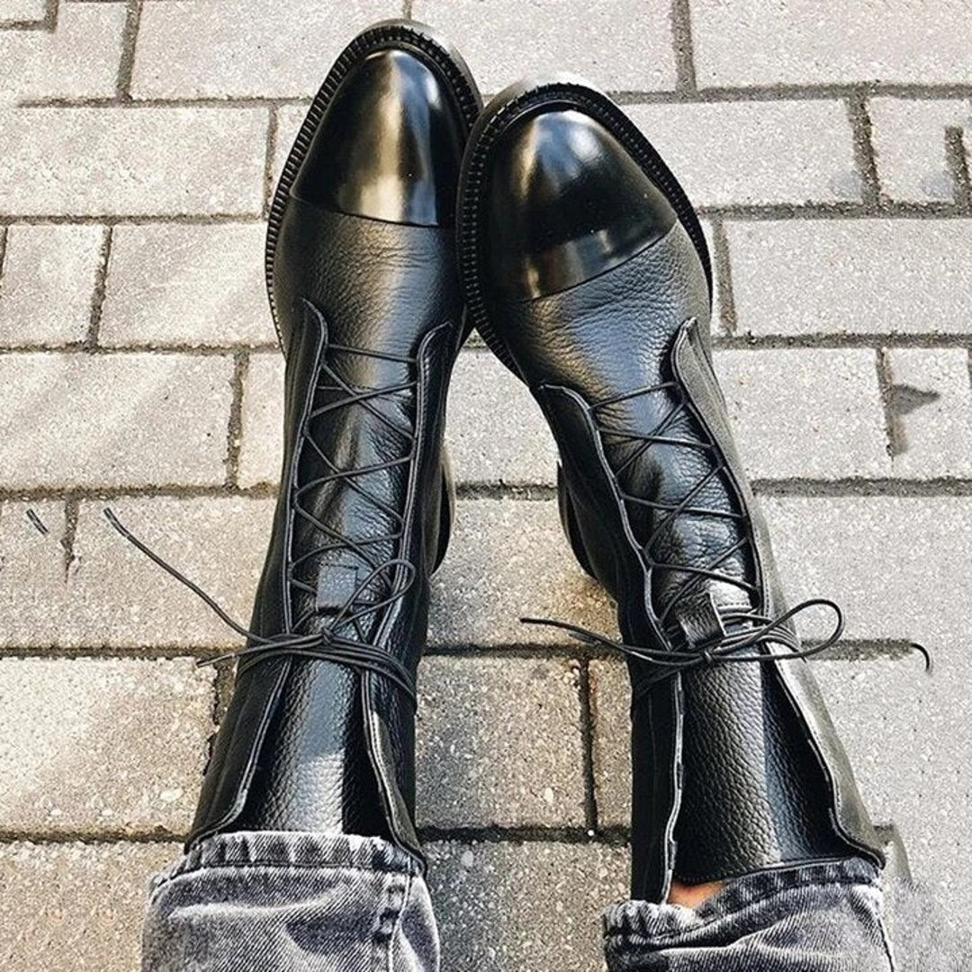 Black lace-up ankle boots on a tiled floor