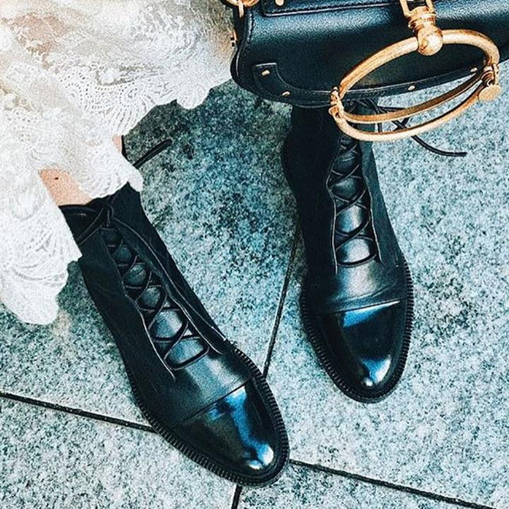 Black polished boots with a gold-tone handbag