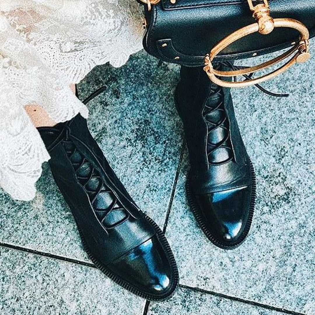 Black polished boots with a gold-tone handbag