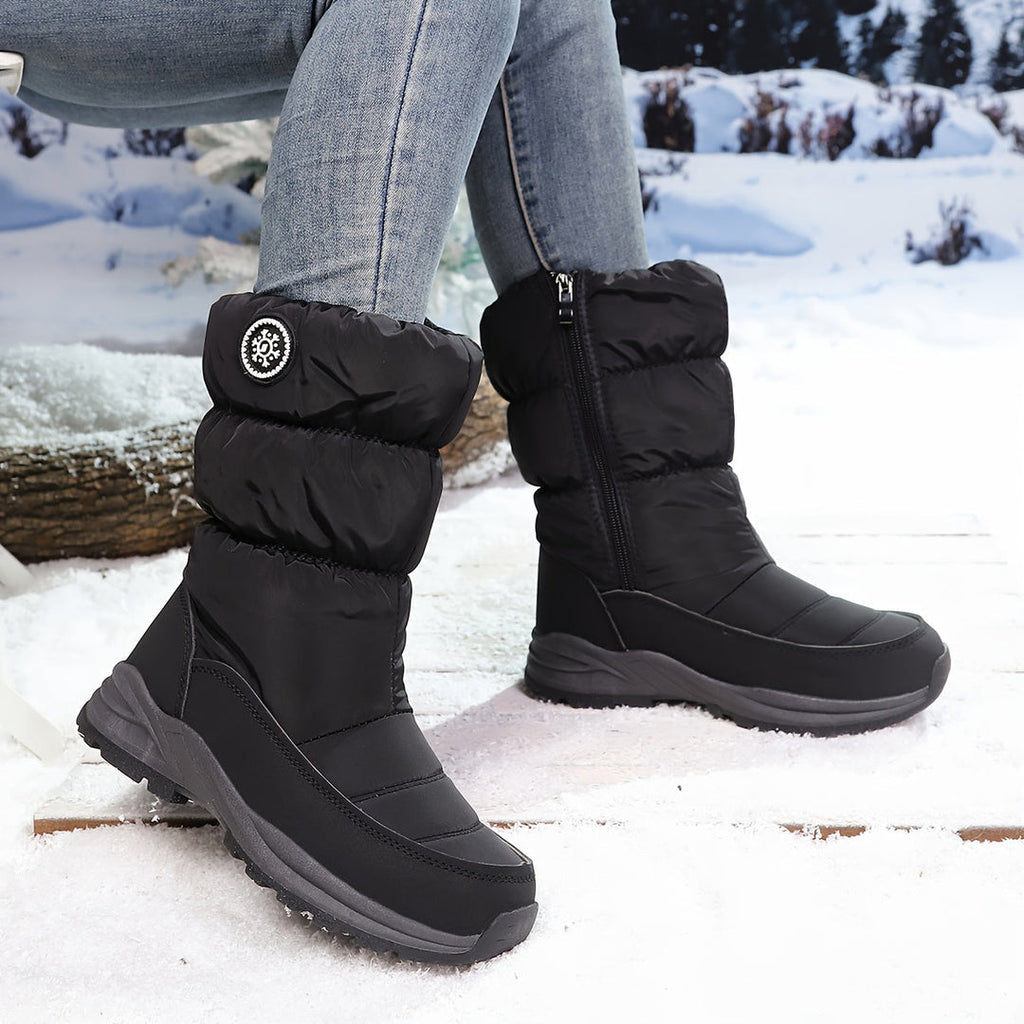 Woman wearing black quilted winter boots in the snow