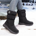 Woman wearing black quilted winter boots in the snow