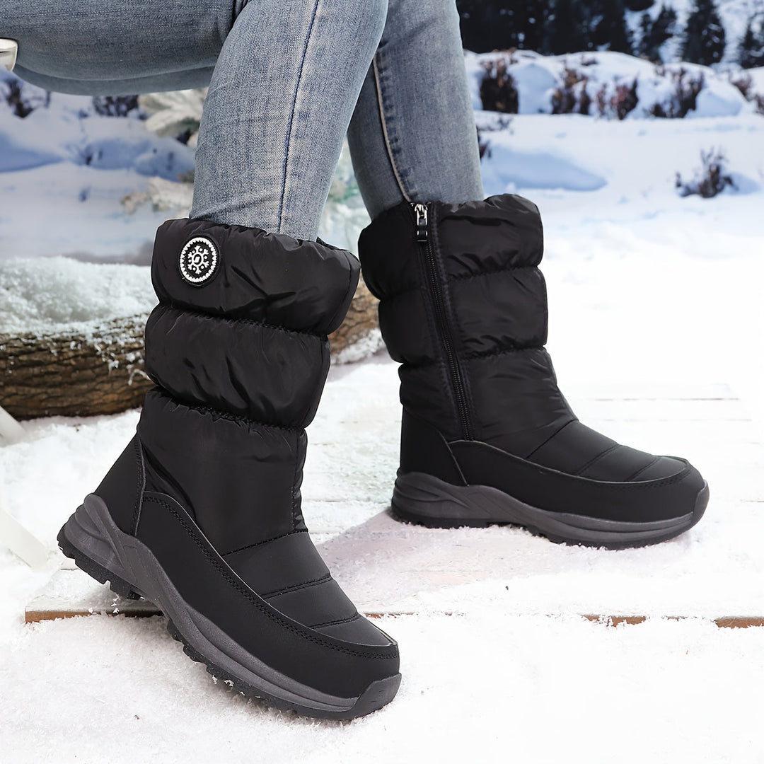 Woman wearing black quilted winter boots in the snow