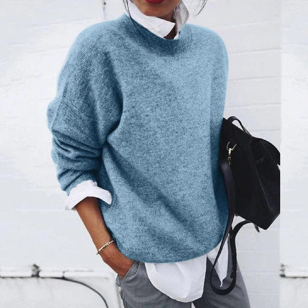 Woman wearing a blue relaxed knit sweater over a white shirt