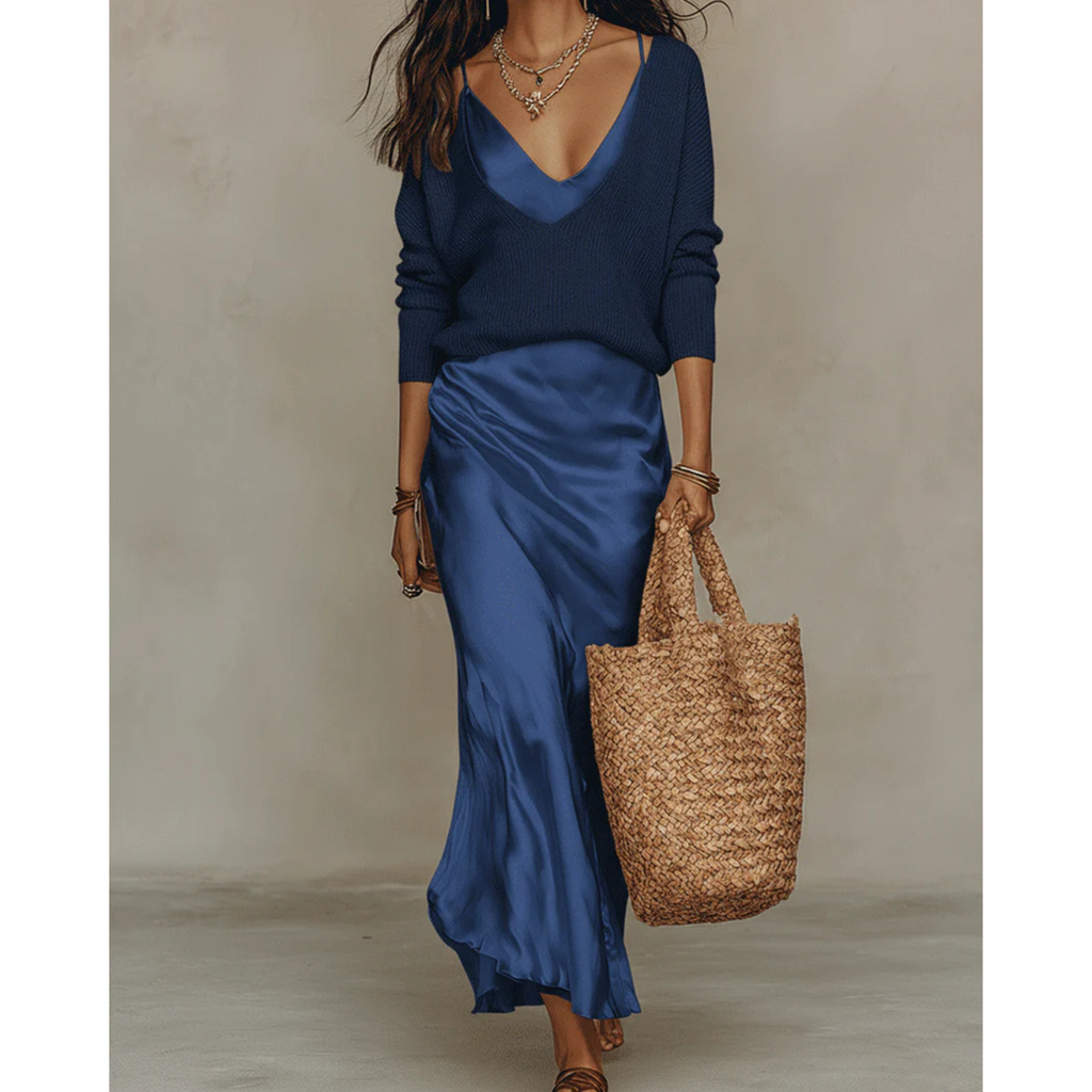 Woman wearing a navy satin midi dress and sweater set