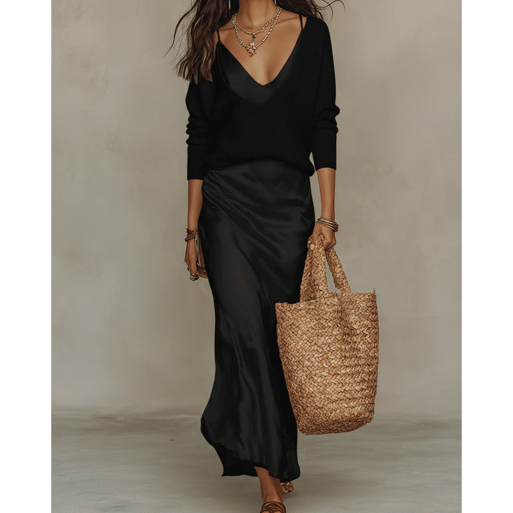 Woman wearing a black satin dress and knit sweater set