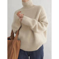 Woman wearing a beige roll neck sweater with a tote bag