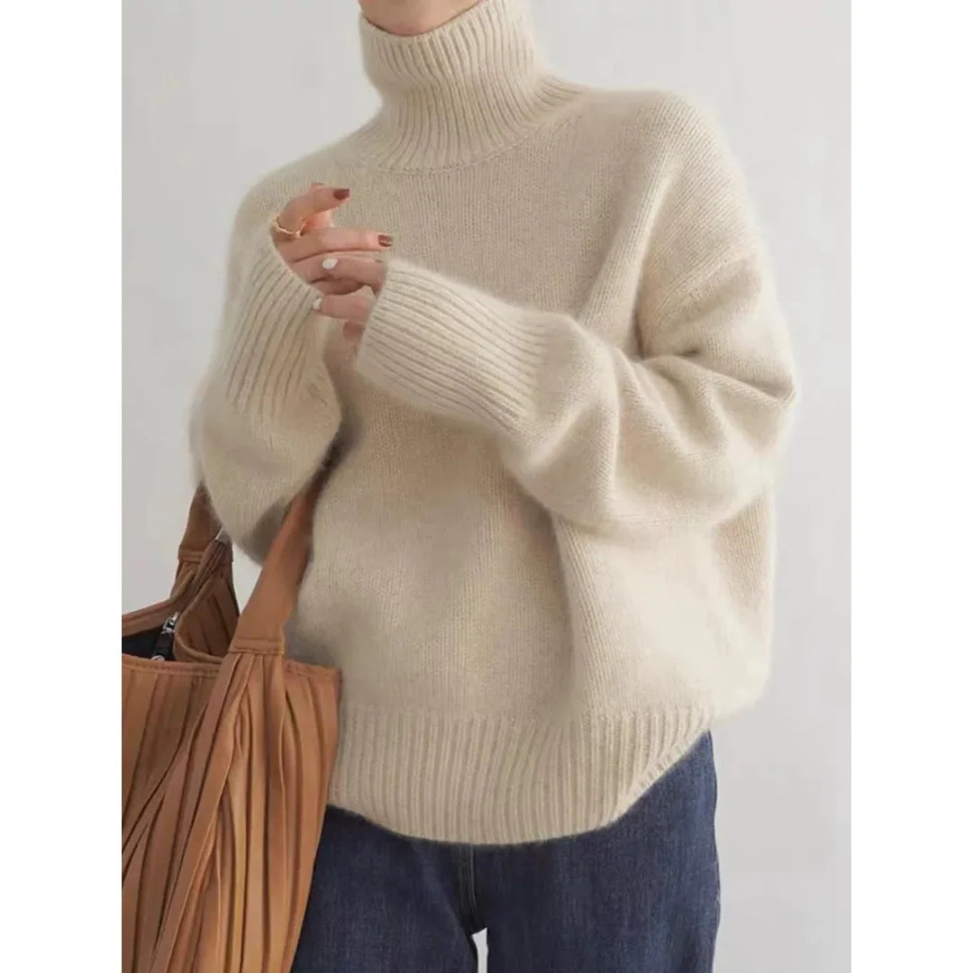 Woman wearing a beige roll neck sweater with a tote bag