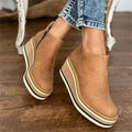 Woman wearing beige wedge platform ankle boots with jeans