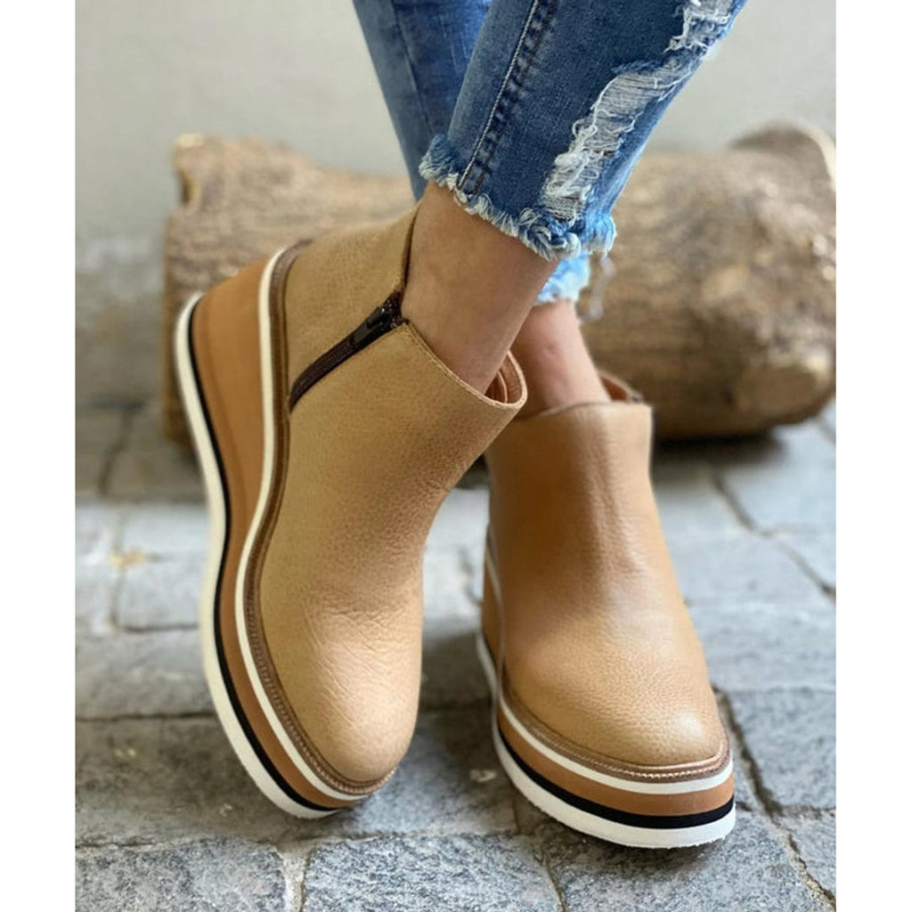 Khaki wedge ankle boots on a stone surface