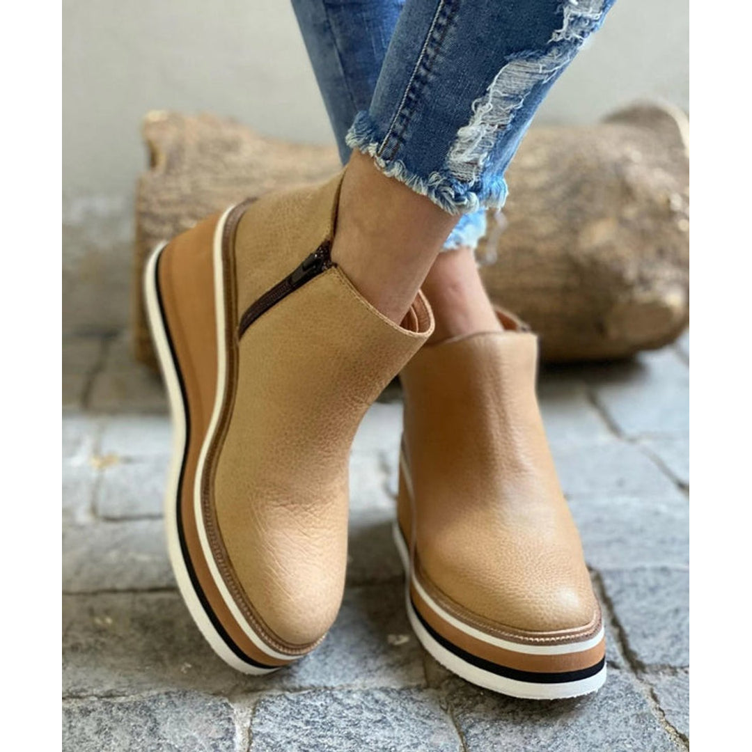 Khaki wedge ankle boots on a stone surface