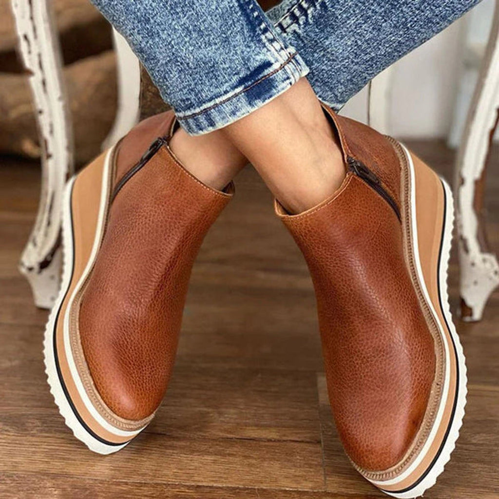 Woman wearing dark brown wedge ankle boots