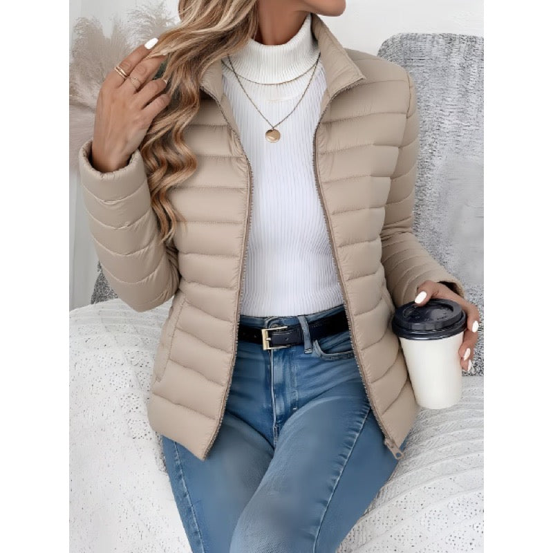 Beige quilted jacket with stand collar worn open with jeans
